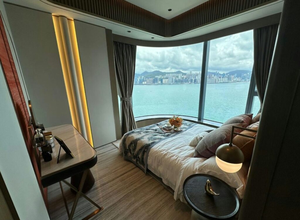 維港‧灣畔第1B期 Victoria Voyage Phase 1B 主人房設有環景玻璃窗，盡覽維港海景，配備化妝枱與雙人床。