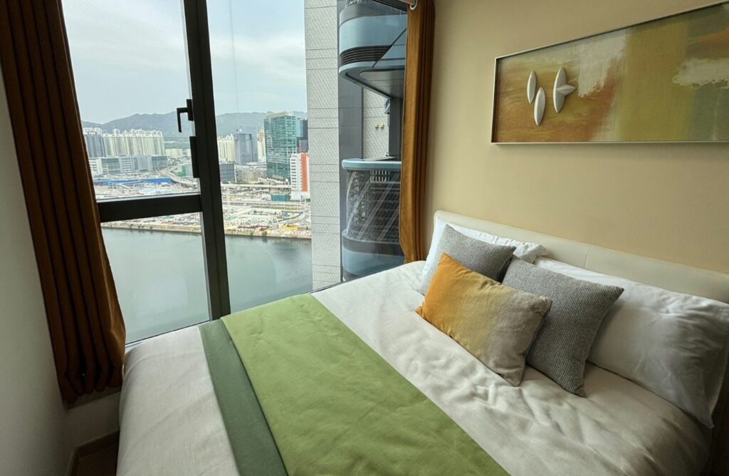啟德海灣2 Kt Marina 2 現代臥室設計配大窗戶海景與城市天際線景觀，舒適雙人床與溫馨裝飾