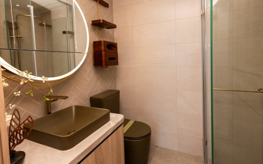 柏傲莊III THE PAVILIA FARM III 浴室空間設計，設有玻璃淋浴間、圓形鏡及簡約洗手台