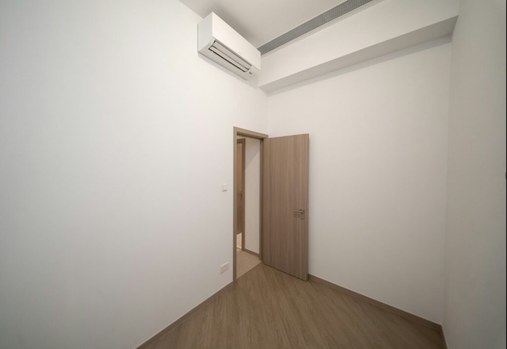 芊御 Garden Regency 交樓標準單位睡房，配備分體式冷氣機、木門及淺色木紋地板